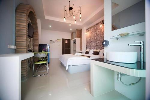 a hotel room with a bed and a kitchen at The Linux Garden Hotel (City Amphur Muang Yala) in Yala