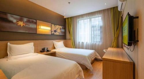 a hotel room with two beds and a television at IU Hotel Kunming Jinma Bijifang Joy City in Kunming