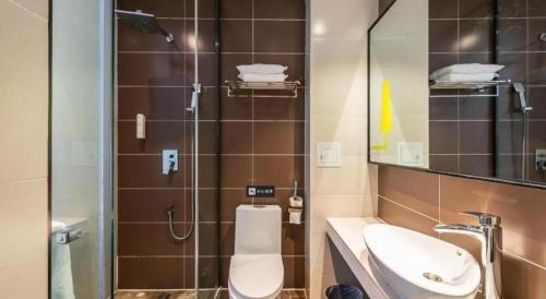 a bathroom with a toilet and a sink and a mirror at IU Hotel Kunming Jinma Bijifang Joy City in Kunming