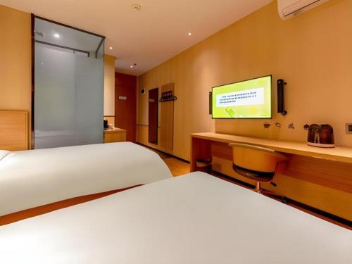 a hotel room with two beds and a television at IU Hotel Kunming Jinma Bijifang Joy City in Kunming