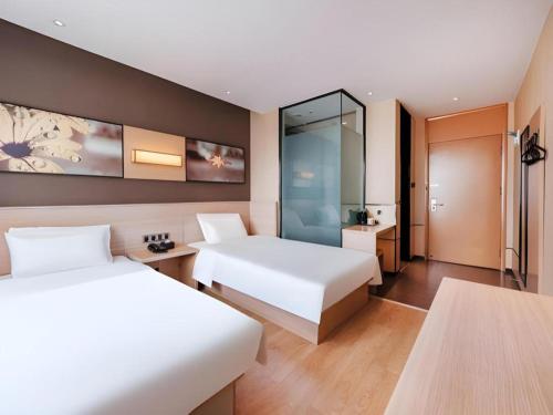a hotel room with two beds and a bathroom at IU Hotel Kunming Jinma Bijifang Joy City in Kunming