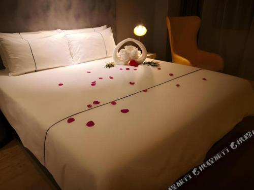 a bed with a bunch of hearts on it at Magnotel Harbin Songbei Wanda Wenlvcheng in Harbin
