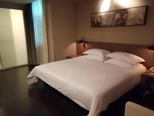 a large white bed with white sheets and pillows at Jinjiang Inn Select Xuzhou High-speed Railway Station Kunpeng Road in Xuzhou