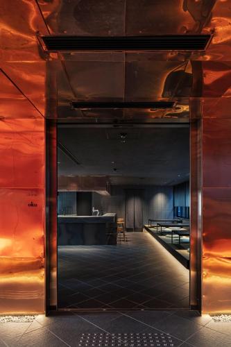 a large room with a red wall and an open door at hotel tou nishinotoin kyoto in Kyoto