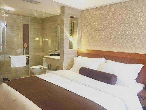 Un dormitorio con una cama grande y un baño. en James Joyce Coffetel Chengdu Century City Convention and Exhibition Center, en Chengdú