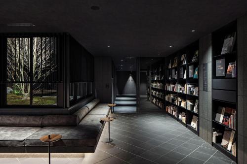 a library with a couch and shelves of books at hotel tou nishinotoin kyoto in Kyoto