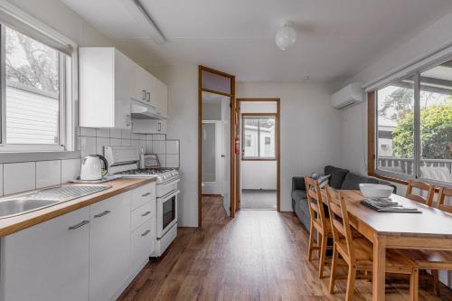 a kitchen with a table and a dining room at Ocean Grove Holiday Park in Ocean Grove