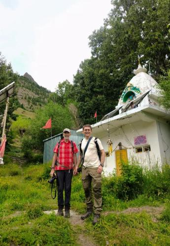 two men walking down a dirt path next to a building at Rupi Rani Home Stay in Gushāl