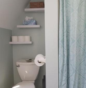 a bathroom with a toilet and a blue shower curtain at Charming Guest House! in Exeter