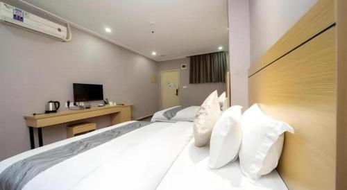 a bedroom with a large bed with white pillows at Ying Feng Yuan Hotel in Guangzhou
