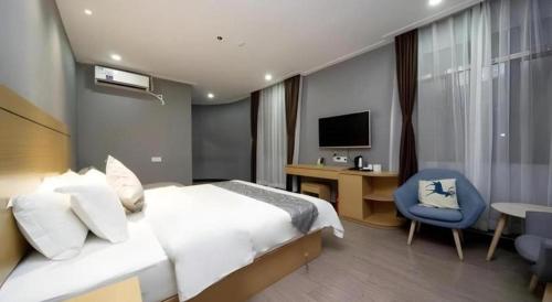 a bedroom with a bed and a desk and a television at Ying Feng Yuan Hotel in Guangzhou