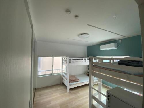 a room with two bunk beds and a window at Tokyo Skytree Tower - Asakusa Auberge de Jeunesse in Tokyo