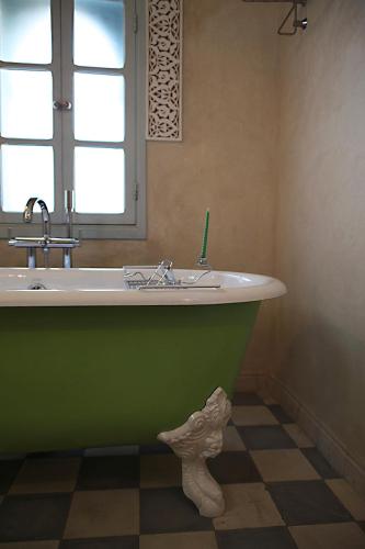 a green bath tub in a bathroom with a window at L'Alcazar in Rabat