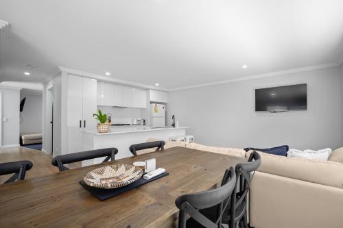 a dining room and living room with a table and chairs at 'Lumeah' - Apartment 1 Central Wagga in Wagga Wagga