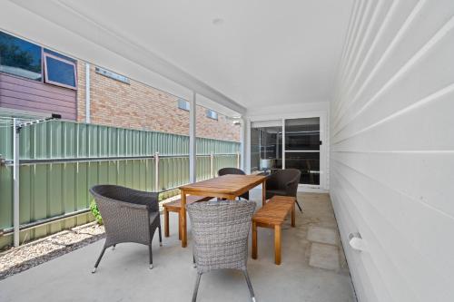 a patio with a wooden table and chairs at 'Lumeah' - Apartment 1 Central Wagga in Wagga Wagga