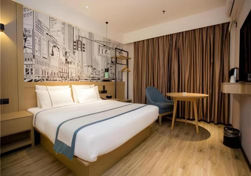 ein Hotelzimmer mit einem großen Bett und einem Tisch in der Unterkunft City Comfort Inn Nanchang Guanying Road Metro Station Maya Paradise in Nanchang
