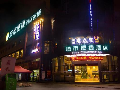 un edificio con insegne al neon di notte di City Comfort Inn Liupanshui Sports Center a Shuicheng