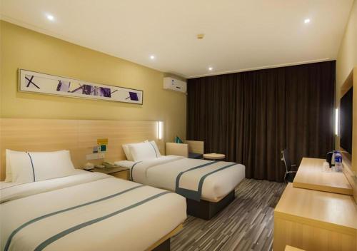 a hotel room with two beds and a desk at City Comfort Inn Liuzhou High-speed Railway Station in Liuzhou