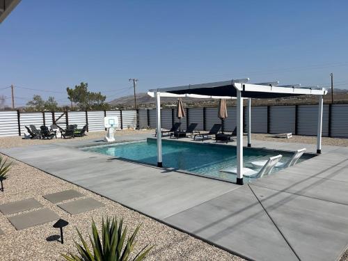 a swimming pool with a pavilion and chairs and a swimming poolvisor at Joshua Tree Poolside Escape! in Twentynine Palms