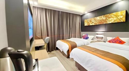 a hotel room with two beds and a flat screen tv at Jun Hotel Hubei Wuhan Jianghan District Jianghan Road Walking Street in Wuhan