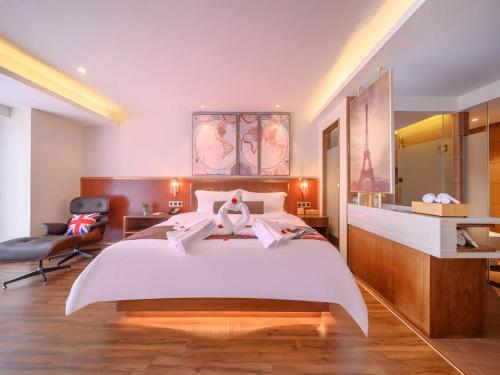 a bedroom with a large white bed and a chair at James Joyce Coffetel Wuhan Gutian Er Road Metro Station in Wuhan
