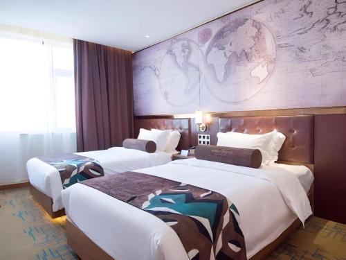 deux lits dans une chambre d'hôtel avec une fresque murale sur le mur dans l'établissement James Joyce Coffetel Xuzhou Feng County Huadi Street, à Feng