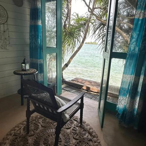 a chair in front of a window with a view of the ocean at Ocean Beach House in Matara