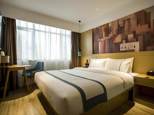 a hotel room with a large bed and a desk at City Comfort Inn Changsha Huangxing Avenue Airport Longhua Metro Station in Changsha