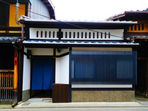 a building with a blue door and a fence at 京一軒町家 さと居 鉄仙 SATOI TESSEN Omiya-Gojo in Kyoto