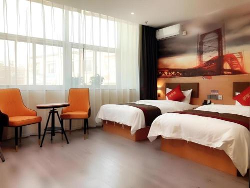 a hotel room with two beds and a table and chairs at Thank Inn Hotel Inner Mongolia Baotou Donghe Haode Trade Plaza in Baotou
