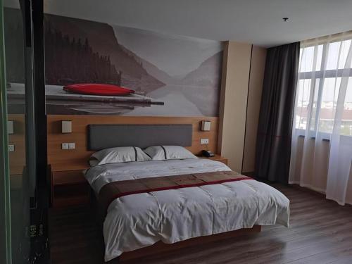 a bedroom with a bed with a painting on the wall at Thank Inn Hotel Jiangsu Wuxi High-Tech Zone Ruigang Pedestrian Street in Wuxi