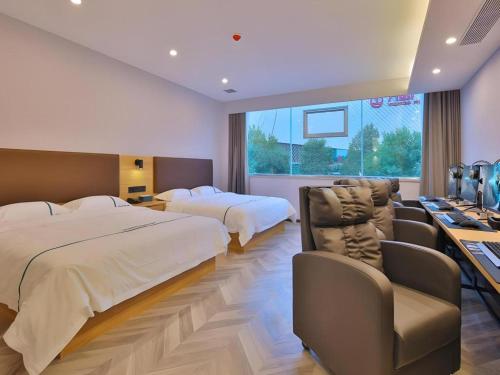 a hotel room with two beds and a television at GreenTree Esports Hotel Qingdao Licang District Wanda in Qingdao