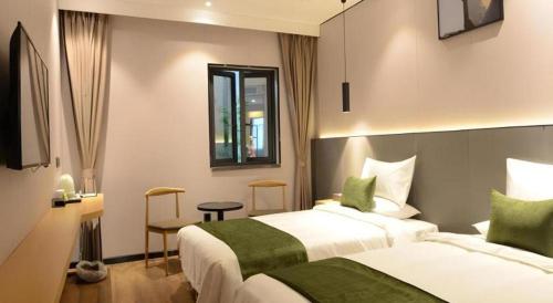 a hotel room with two beds and a window at Green Tree Inn Express Fuzhou Three Lanes and Seven Alleys Nanmendou Metro Station in Fuzhou