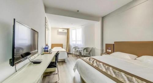 a hotel room with two beds and a flat screen tv at GreenTree Alliance Hotel Qinghuangdao Wanda Plaza in Qinhuangdao