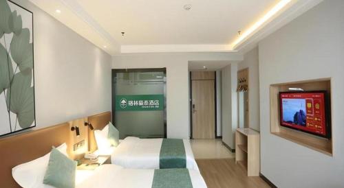 a hotel room with a bed and a television at GreenTree Inn Anqing Yingbin Dong Road High-Speed Railway Station in Anqing