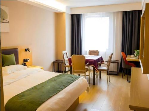 a hotel room with a bed and a table and chairs at GreenTree Inn Express Chuzhou Langya District Government Chuhe Road in Chuzhou