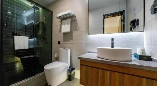 a bathroom with a toilet and a sink and a shower at GreenTree Inn Express Hebei Tangshan Guyan District Xinguang Road in Tangshan