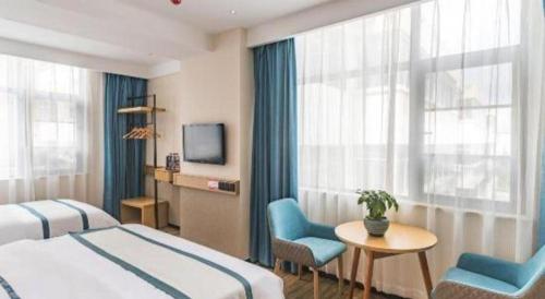 a hotel room with two beds and a table and chairs at City Comfort Inn Lhasa Potala Palace Scenic View in Lhasa