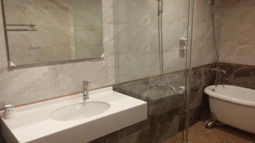 a bathroom with a sink and a glass shower at Happy Hotel in Magong