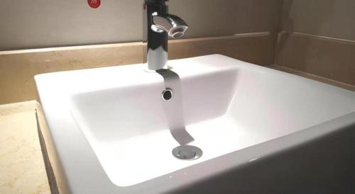 a sink with a faucet in a bathroom at Borrman Hotel Liuzhou High-Speed Railway Station in Liuzhou