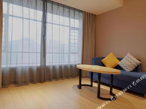 a living room with a blue couch and a table at Borrman Hotel Liuzhou High-Speed Railway Station in Liuzhou