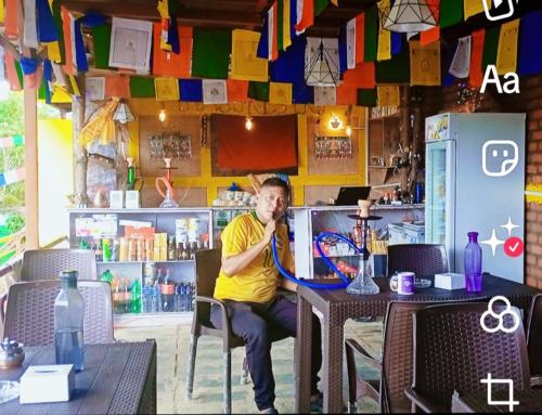 a man sitting at a table in a restaurant at Everest Home Stay Temal Kalimati Tower in Thapathali