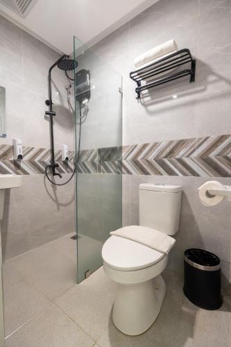 a bathroom with a toilet and a shower at Maharlika City Inn in Bacolod