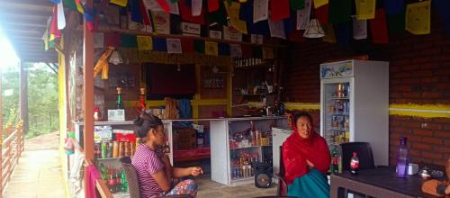 two women sitting in a room with flags on the wall at Everest Home Stay Temal Kalimati Tower in Thapathali
