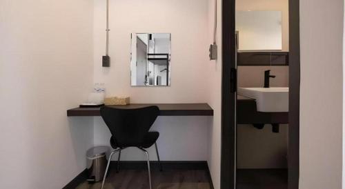 bagno con sedia nera e lavandino di ZK Hotel Chiangmai a Chiang Mai