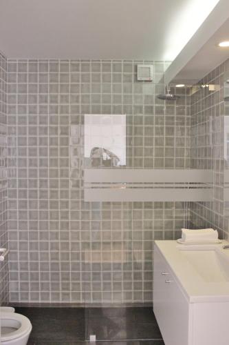 a bathroom with a white toilet and a sink at Aldeia do Priolo in Nordeste