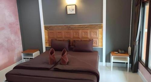 a bedroom with a large bed with two pillows at Kidthuengpark in Si Racha
