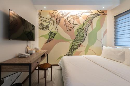 a bedroom with a bed and a wall with a painting at Maharlika City Inn in Bacolod