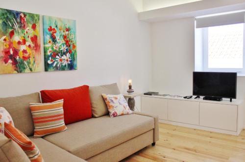 a living room with a couch and a flat screen tv at Aldeia do Priolo in Nordeste