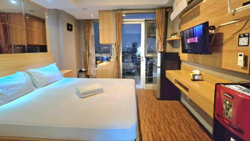 a hotel room with a bed with a book on it at Studio Apartment JiExpo Kemayoran View -Min Stay 3 nights- in Jakarta
